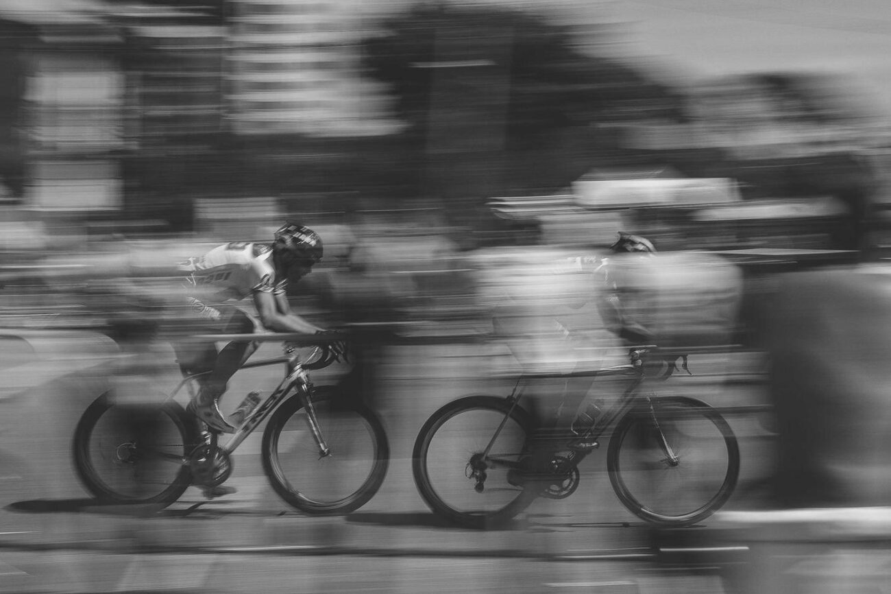 Cyclists racing through urban environment with motion blur effect.